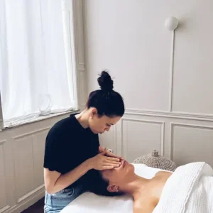 Justine masse une cliente le visage pour un soin du visage anti ride permettant à la peau de bien vieillir